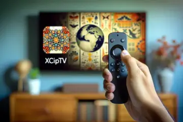 alt_text: A hand holding a Firestick remote points at a TV showing the XCIPTV app for a tutorial guide.